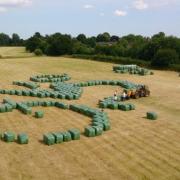 Big job! The team putting together the bales of hay to form the cyclist in the field sculpture