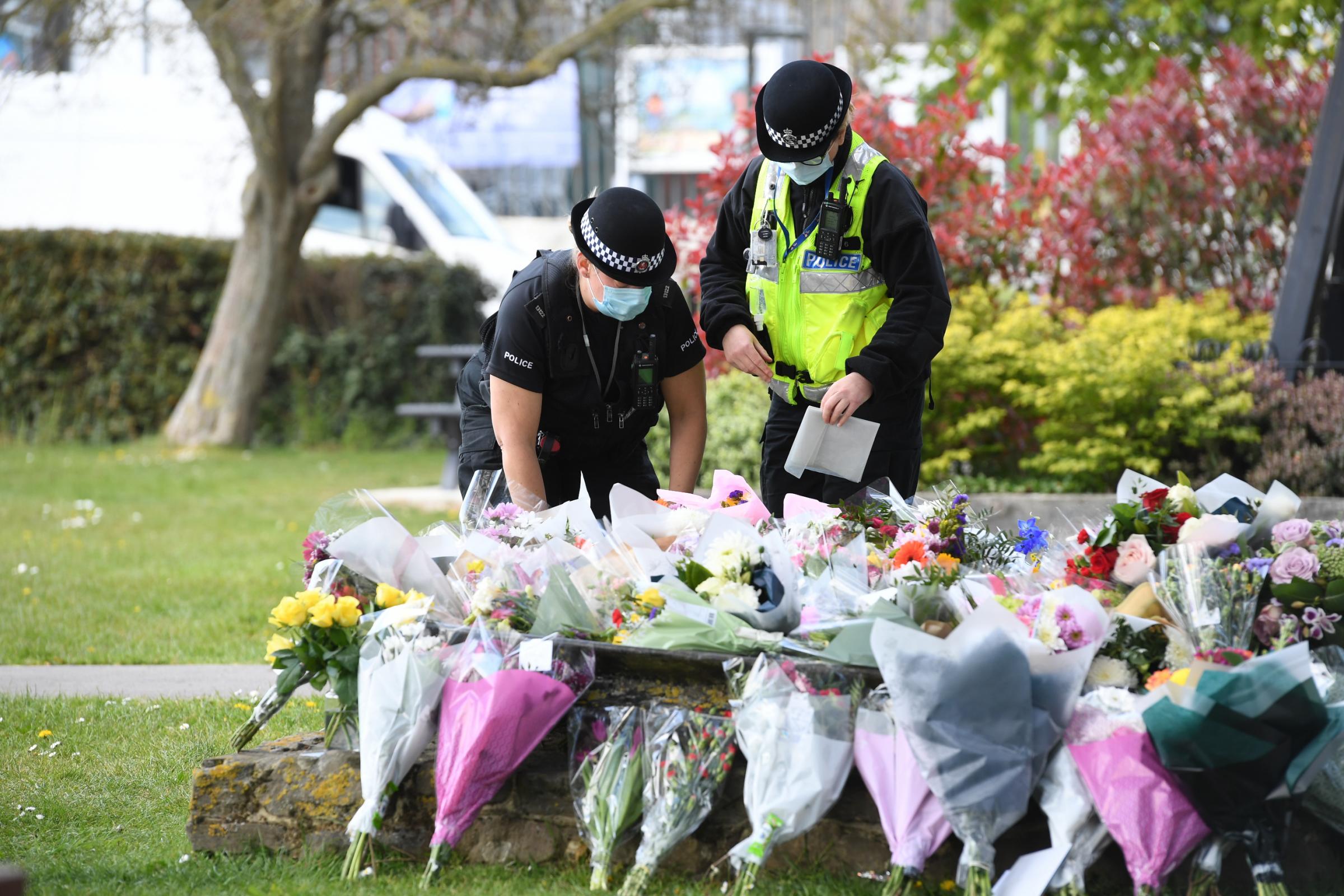 Two police officers lay floral tributes in a park in Aylesham village close to the scene in Snowdown, Kent, where the body of PCSO Julia James was found. Picture date: Saturday May 1, 2021.